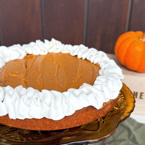 Close up of fluffy homemade whipped cream piped onto pumpkin pie